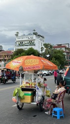 Puesto callejero ambulante, The Frangipani Royal Palace Hotel al fondo
