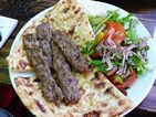 Kofte sobre una base de pide y ensalada